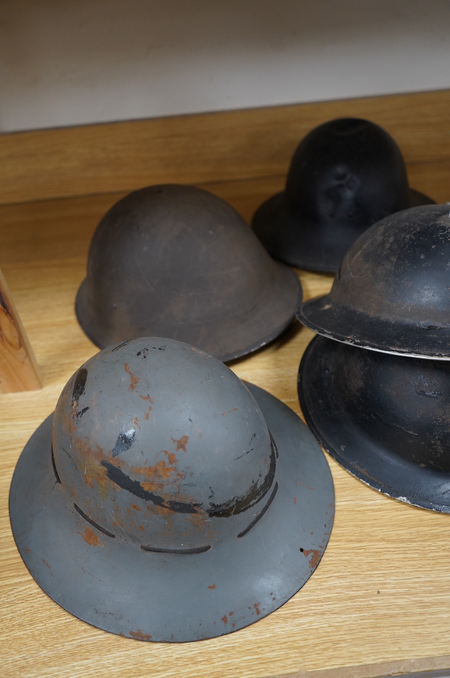 Seven early to mid 20th century military tin helmets; including one stencilled with POLICE. Condition - poor to fair.